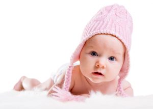 Portrait of three months old baby girl wearing pink winter hat