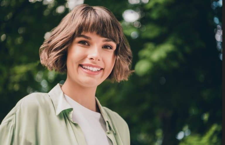 Young female model smiling outdoors during spring photo shoot in natural light