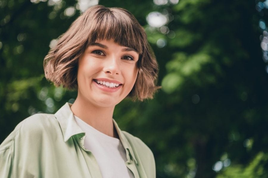 Young female model smiling outdoors during spring photo shoot in natural light